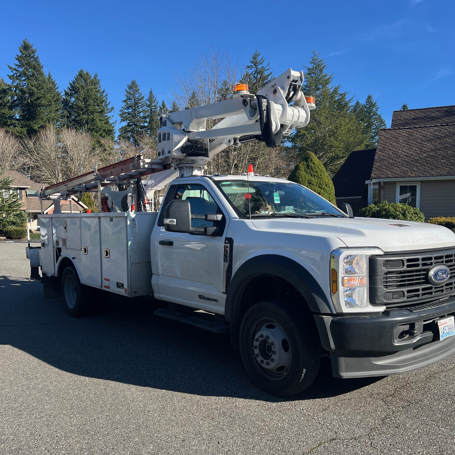 Large white truck with aerial lifft.