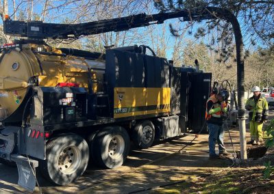 Large vactor truck working in the street.